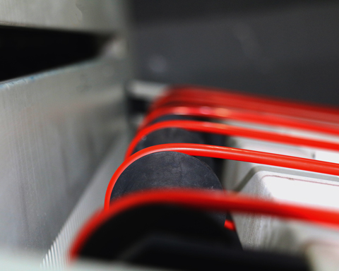 close up of red plastic in roller machine