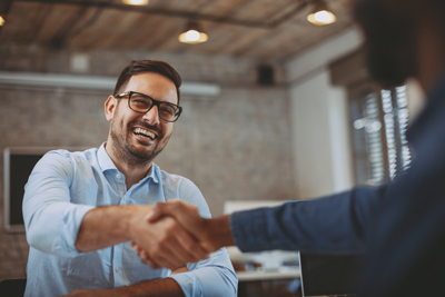 smiling client shaking hands after work deal